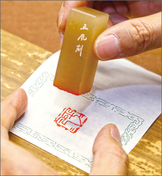 彫り上がった印章に朱肉をつけ、捺印。一つの印章につき、最初の捺印は一度だけ。紙から離したときの鮮やかな朱の印影。この感激を味わえるのは、制作者の特権です。